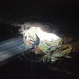 Nella grotta si accede solamente calandosi dall'alto, legati a una corda e muniti di elmetto protettivo...